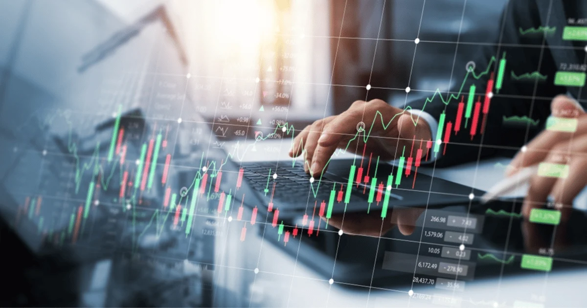 Hand Typing on Laptop With Stock Chart Overlay