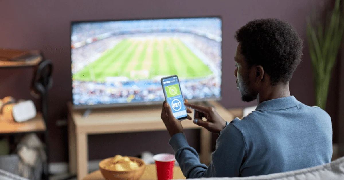 Man With Phone and TV Sports Betting
